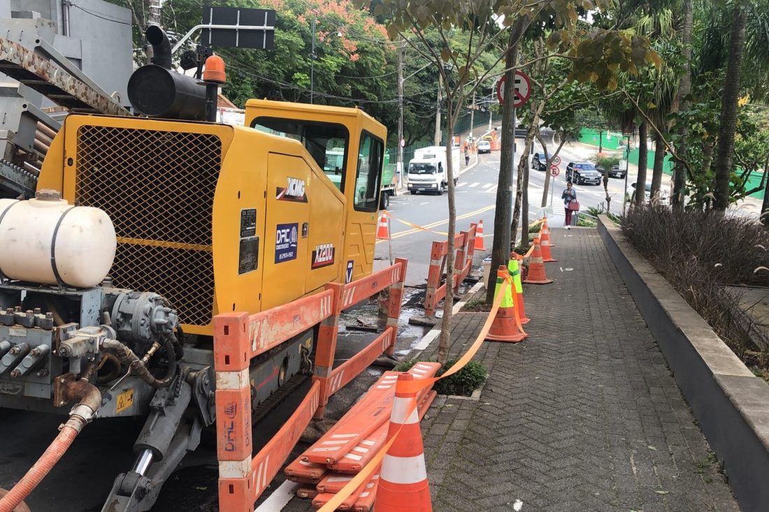 Frente de perfuração direcional da DRC na calçada, com a avenida em operação normal durante a obra