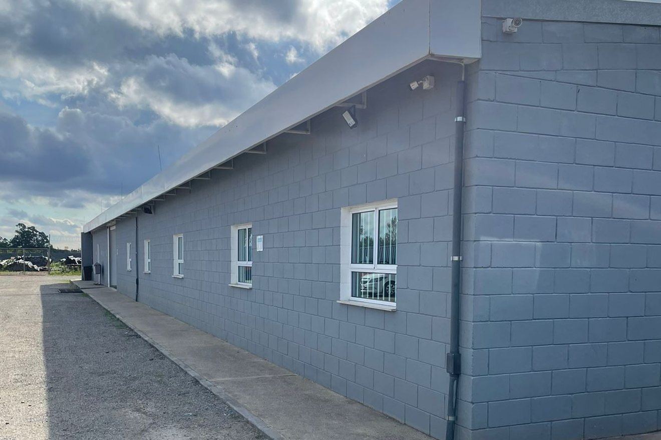 Fachada da sede própria da DRC em Guarulhos, galpão industrial sob céu azul